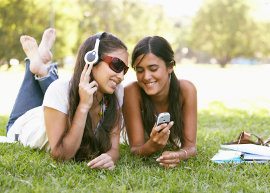 duas meninas ouvindo música e olhando o celular