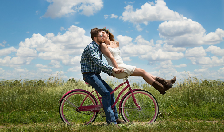 casal se beijando em cima de uma bicicleta