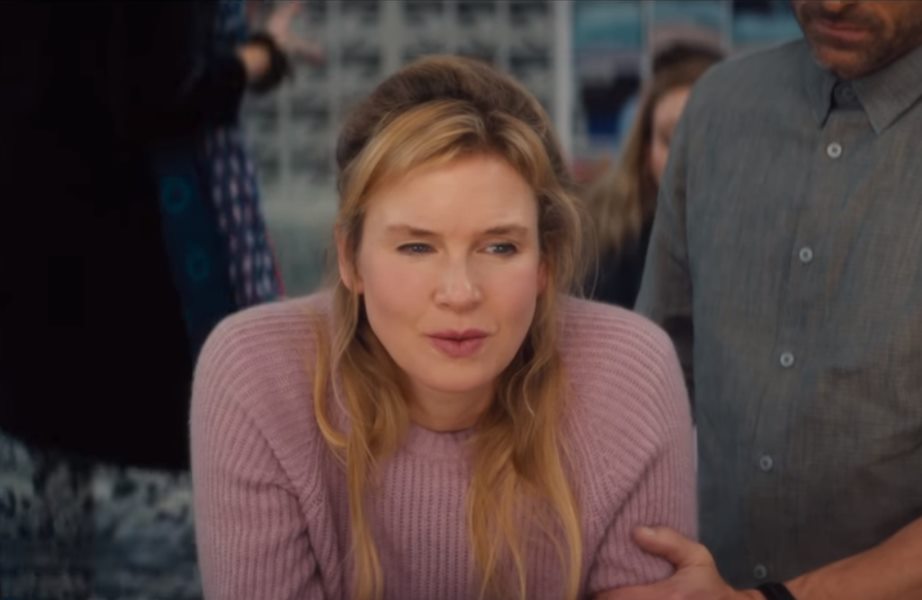 Bridget Jones confusa de blusa rosa no trailer de seu novo filme