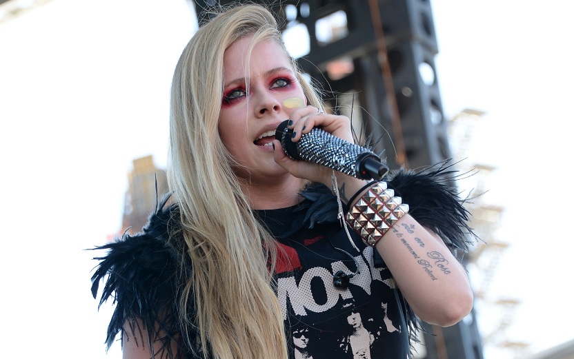 Avril Lavigne cheia de acessórios representando o dia do rock