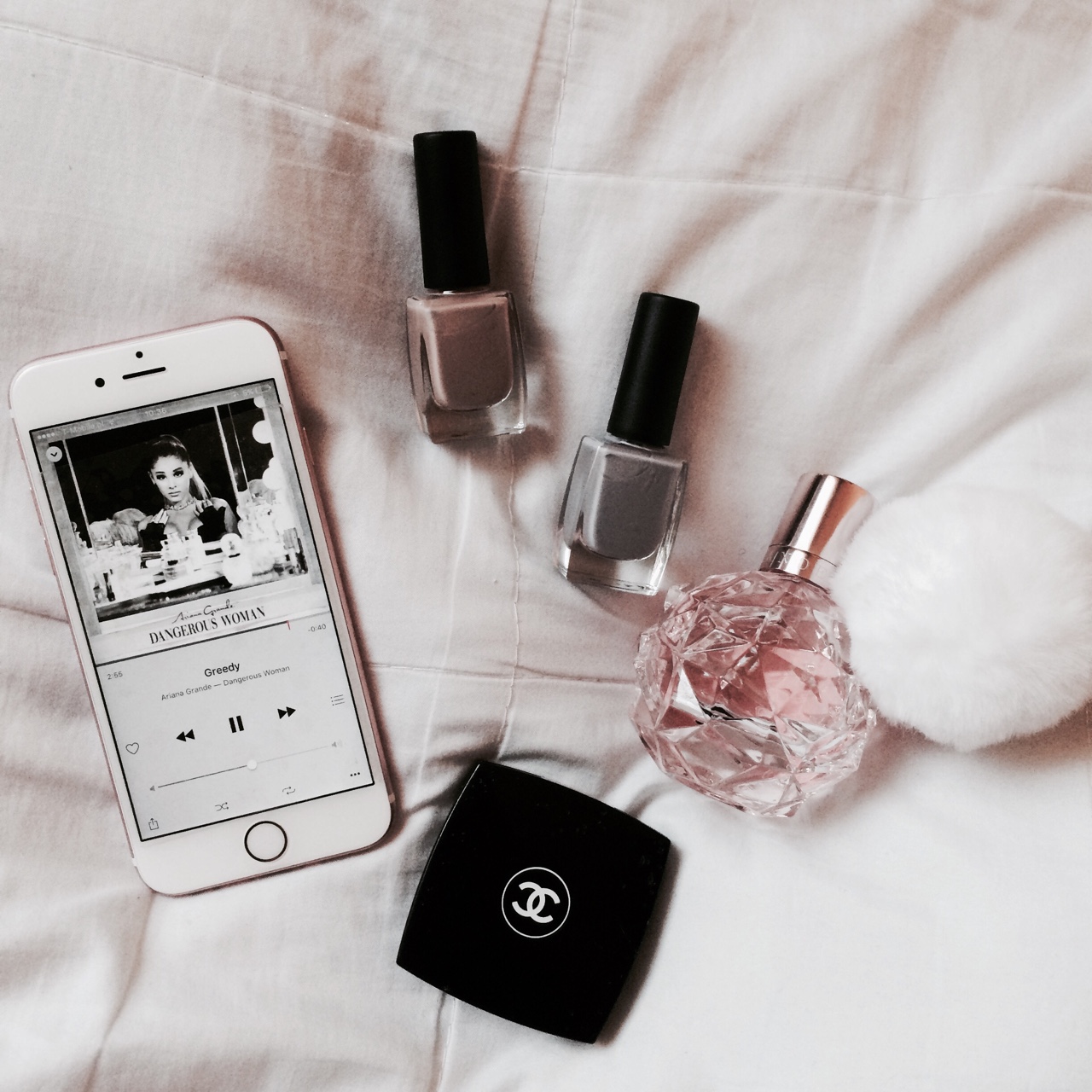 Iphone com música da Ariana Grande em um fundo rosa