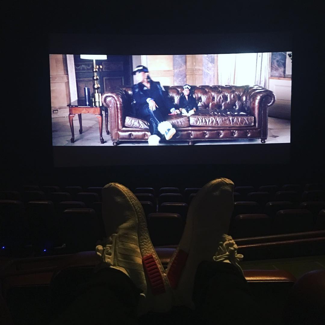 Justin Bieber com os pés na poltrona do cinema