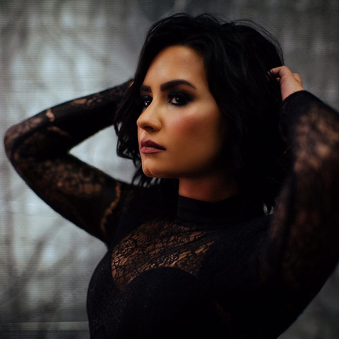 Demi Lovato com as mãos nos cabelos