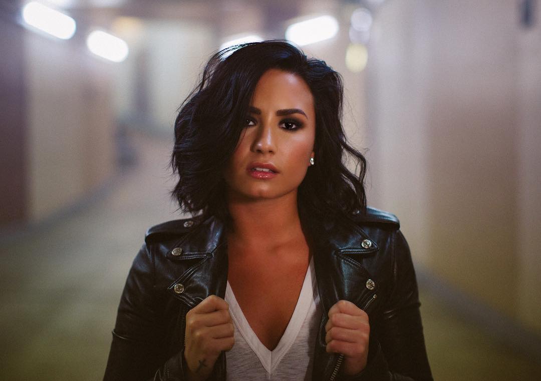 Demi Lovato com cabelo curto e uma jaqueta de couro