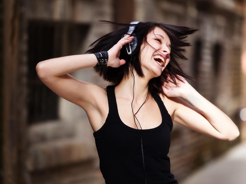 MEnina feliz ouvindo música com fone