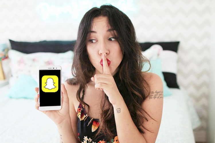 bruna vieira fazendo sinal de 'sh' e segurando um celular com snapchat