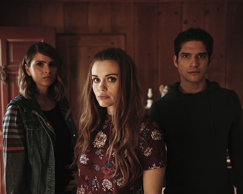 Três atores da série Teen Wolf em fundo vermelho