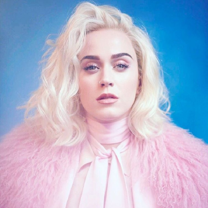 Katy Perry com cabelo platinado vestindo roupas em rosa claro