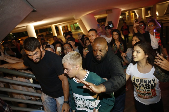 Justin Bieber em restaurante na Zona Sul do Rio acompanhado de seguranças e rodeado por fãs.