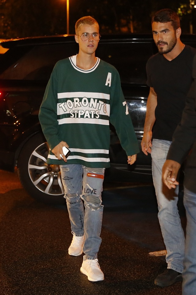 Justin Bieber caminha com segurança próximo ao restaurante em que foi jantar no Rio.