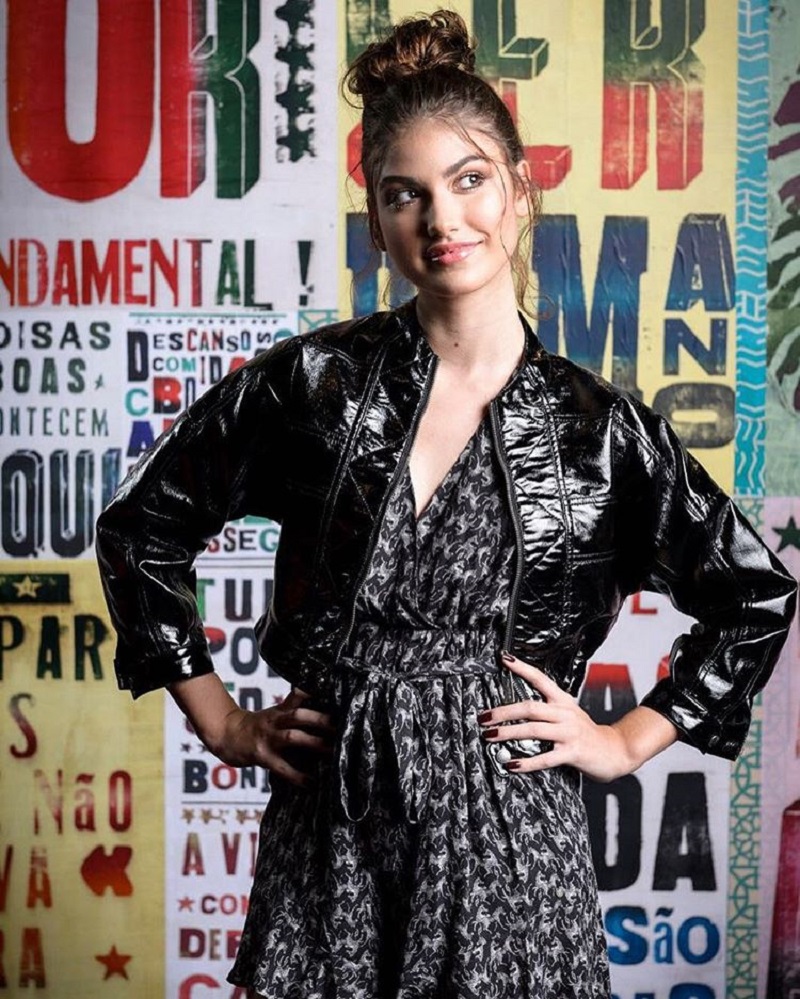 Giovanna Grigio de coque alto, jaqueta de couro e vestido preto estampado