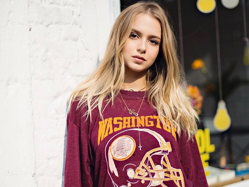 Isabella Scherer em pé de cabelo solto e camiseta vinho