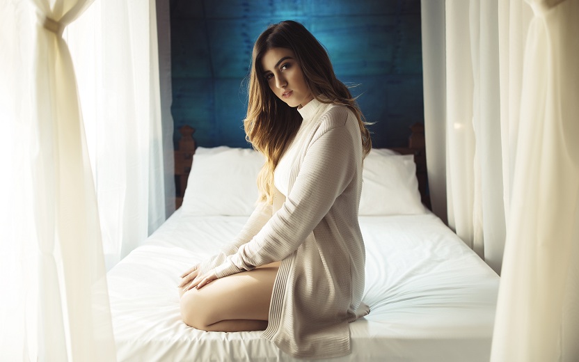 Sofia Oliveira de branco sentada na cama