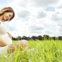 Menina grávida sentada ao ar livre
