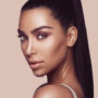 Kim Kardashian de cabelos presos olhando para a câmera
