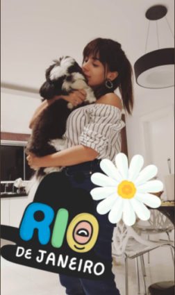 Anitta segurando cachorra e usando franja