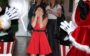 Larissa Manoela usando vestido vermelho e tapando os olhos em frente ao Mickey e a Minnie