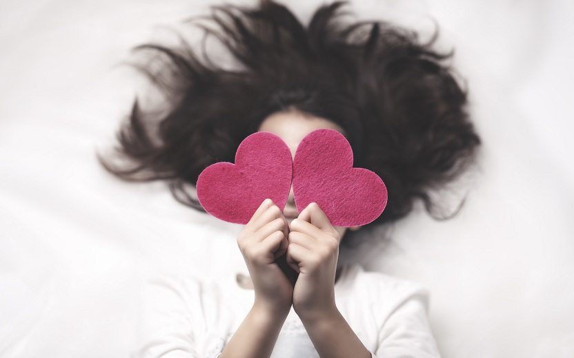 Menina com corações de EVA na mão para você descobrir como será seu Dia dos Namorados
